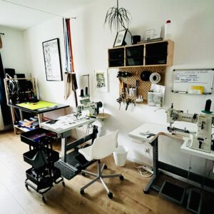 Werkstatt von Roampacks mit Nähmaschinen, Stoffrollen und einfallendem Sonnenlicht.