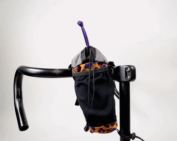 ein Roampacks Snack Bag mit Leo-Stoffmuster wird einhändig geöffnet und geschlossen.